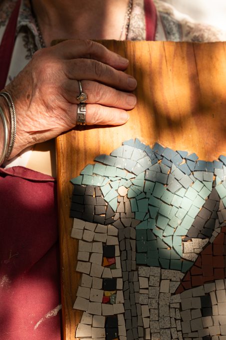 Mosaïque d'un village aux toits bleus, montée sur bois, tenue à deux mains